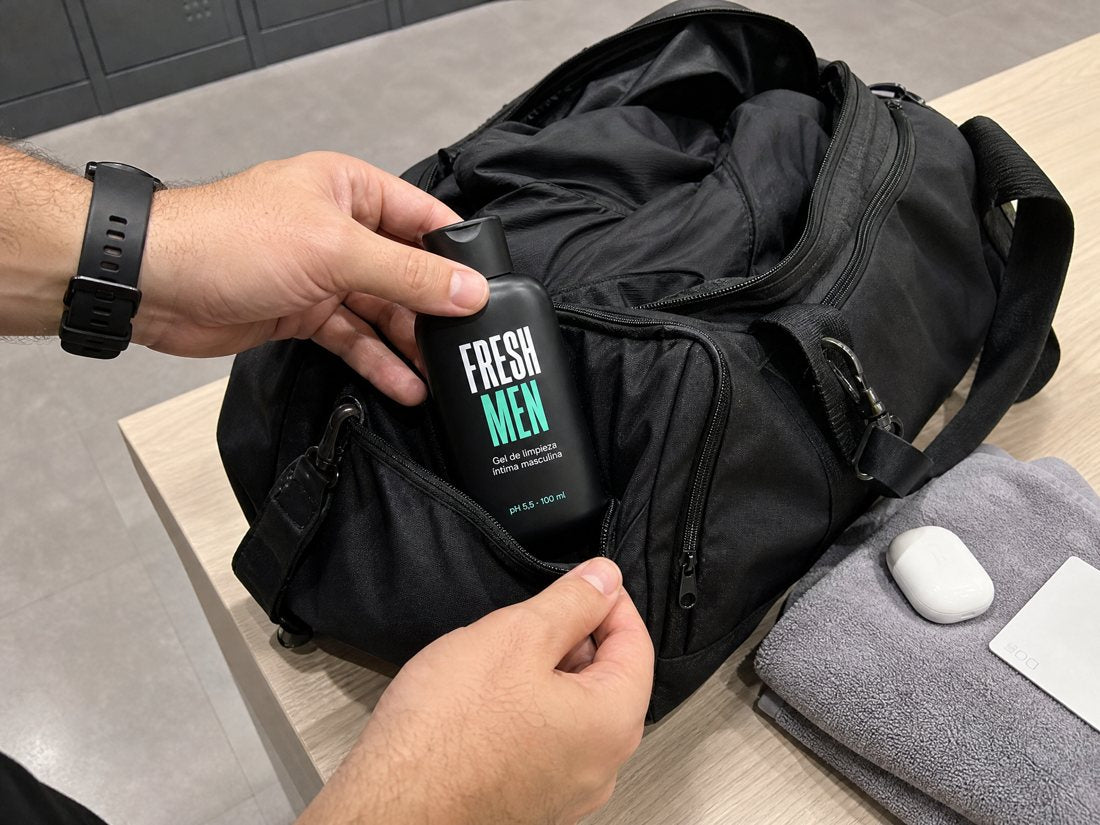 Manos guardando Fresh Men en el bolso del gimnasio